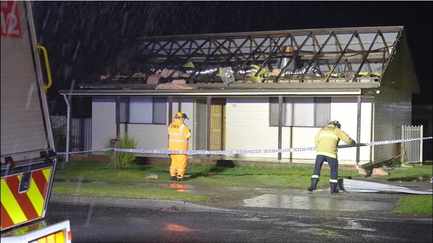 two emergency workers outside a house with no roof