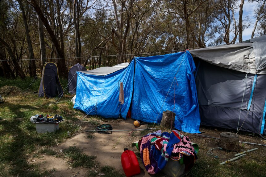 Tarps cover the entrance to a tent, home to a family of four in bushland outside Bendigo.