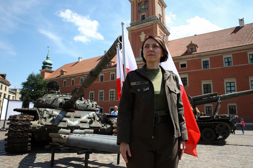Deputy Ukrainian Defence Minister Hanna Maliar poses for a picture in front of army tanks. 