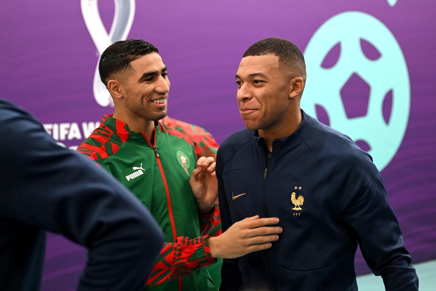 Achram Hakimi touches Kylian Mbappe's chest and both smile