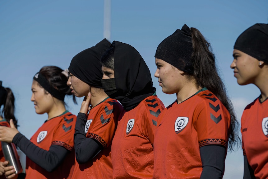 Four members of the Afghan refugee women's team standing in a line at training.