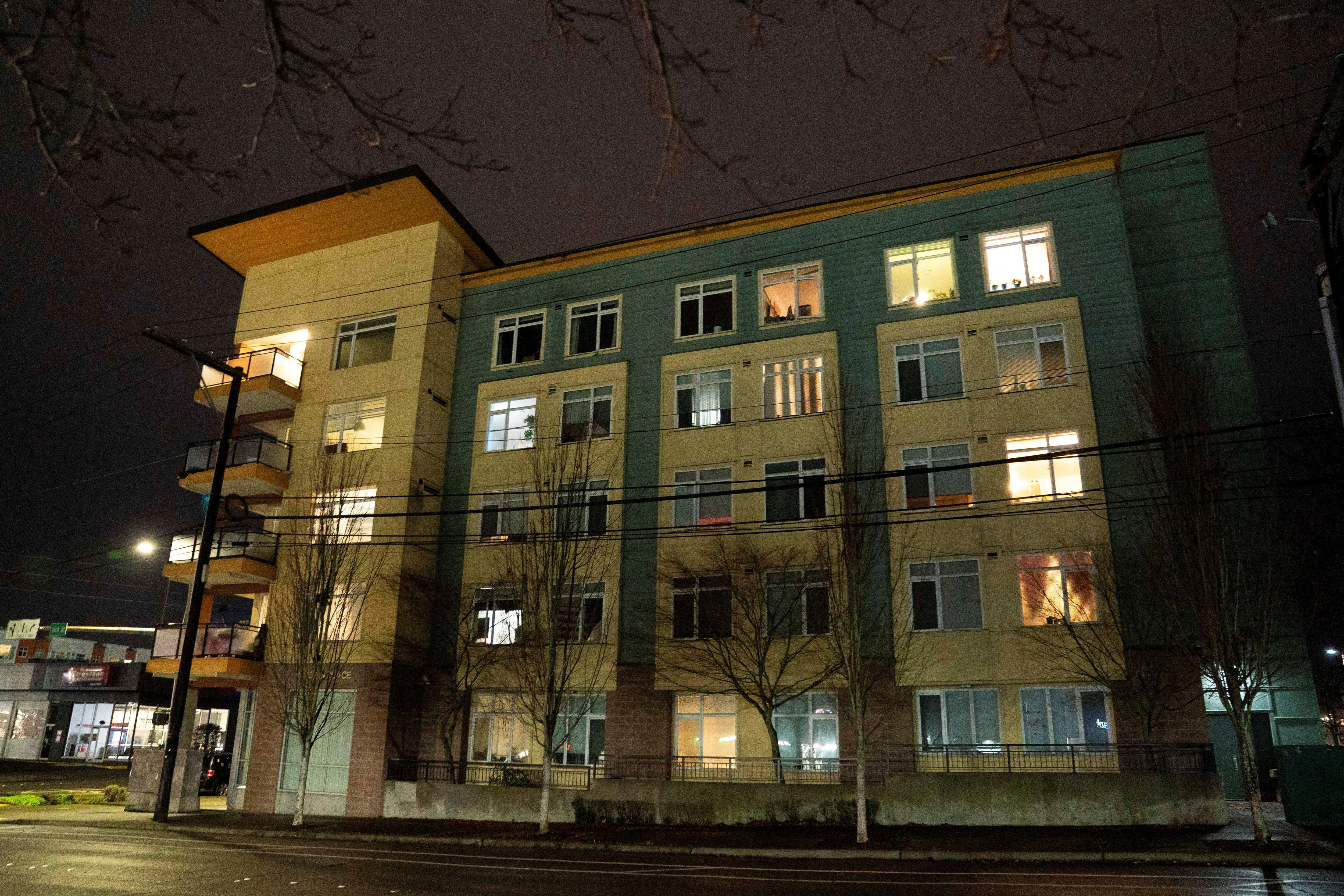 An apartment block lit up in the dark.