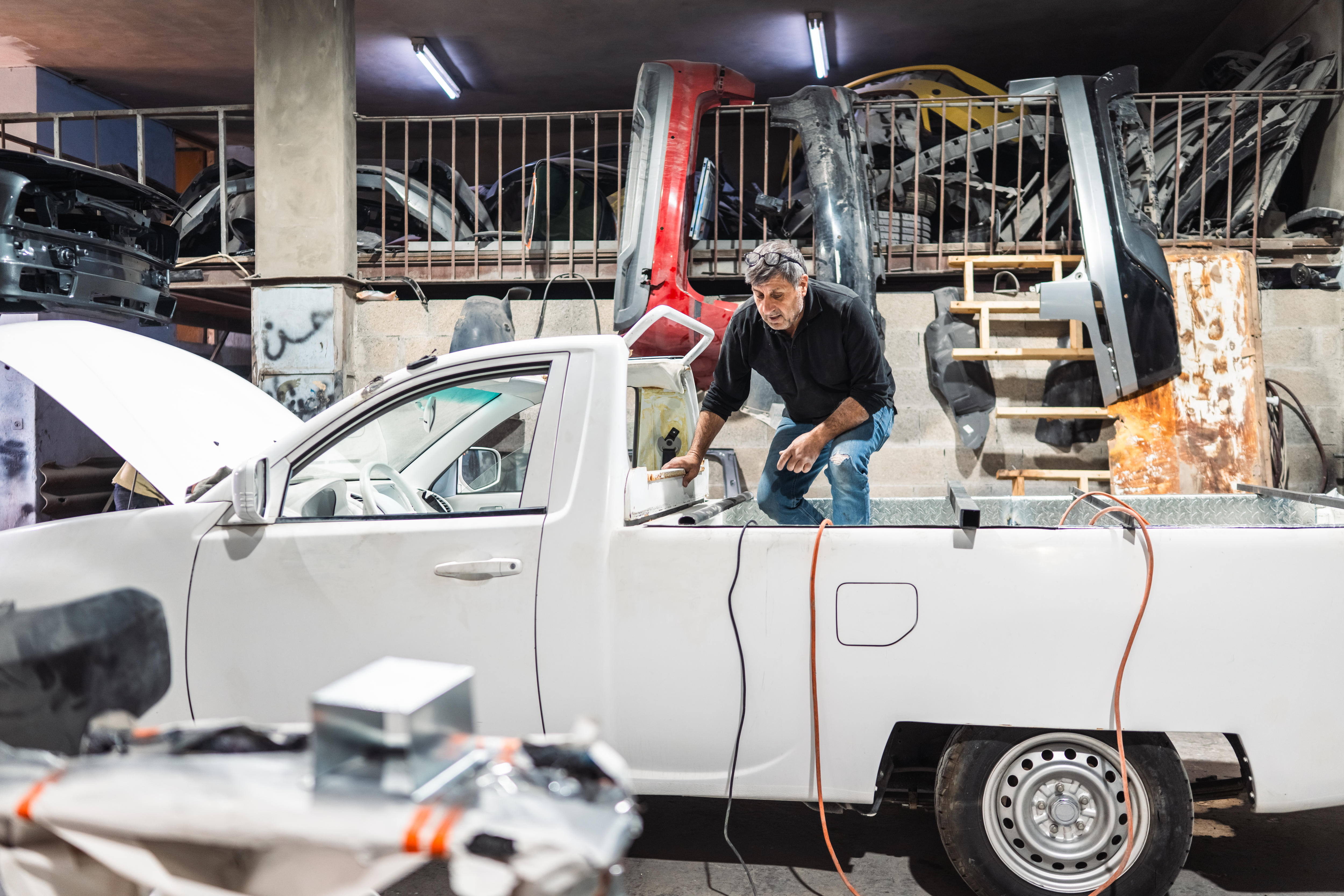 A man standing in the truckbed of a using tools