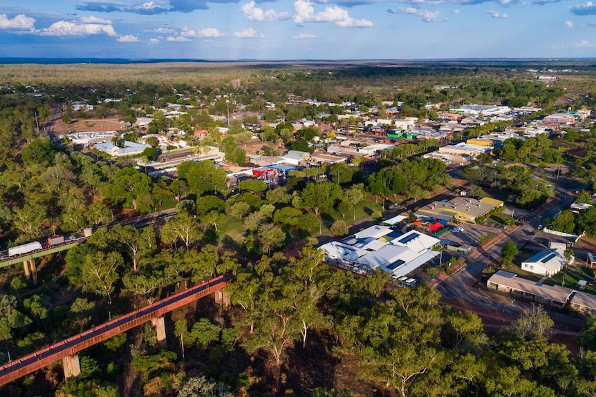 An aerial shot of a country town surrounded by trees and the outback.