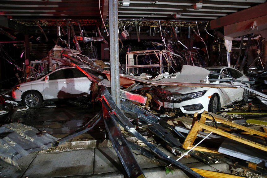 Wrecked cars and damage is seen inside a car dealership after a tornado swept through the area.