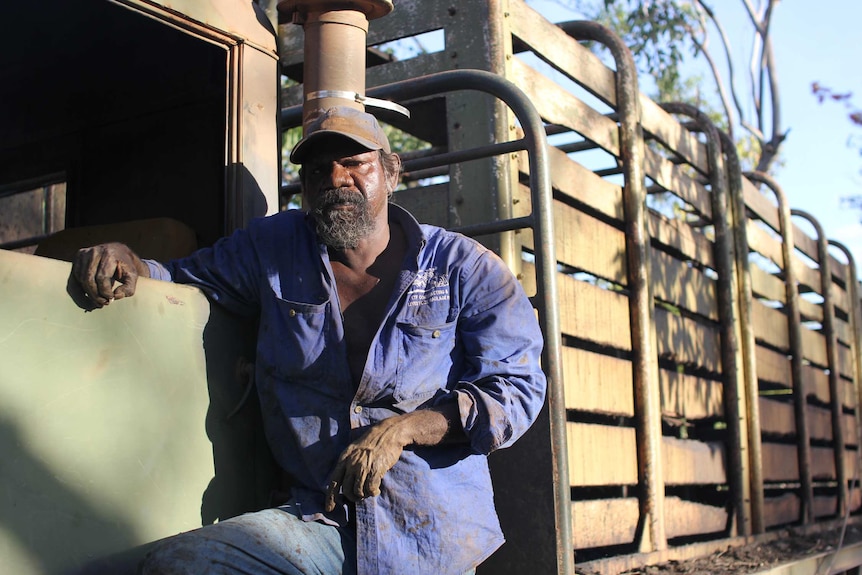 Timothy Martin leans against the door of a livestock transport truck.