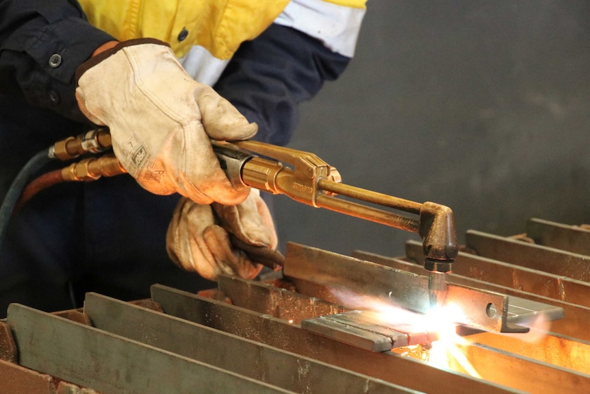 A boiler maker using a welder at a TAFE workshop.