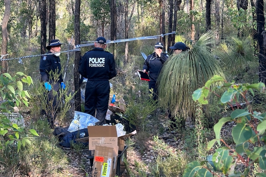 Police officers in dense bushland.