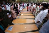 Christians mourn next to the coffins of their relatives killed in a suicide attack on a church in Peshawar.
