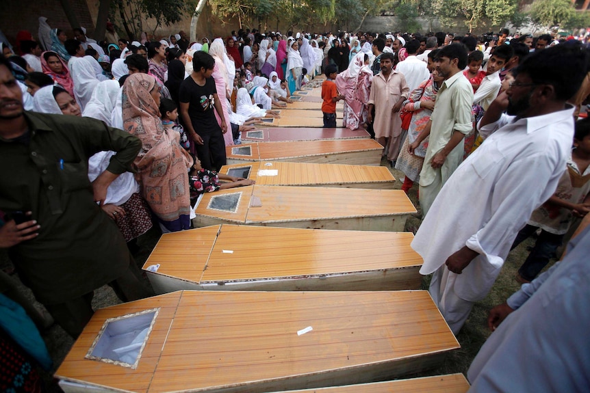 Christians mourn next to the coffins of their relatives killed in a suicide attack on a church in Peshawar.