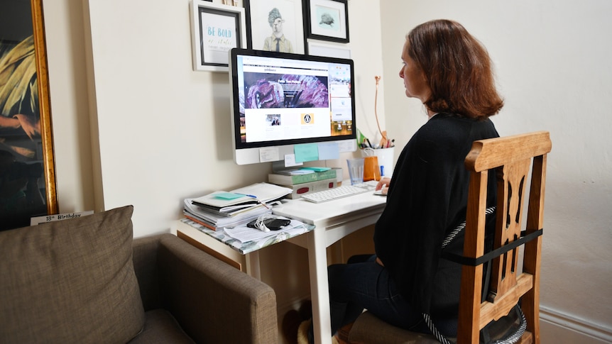 a woman sitting in front of a computer desk