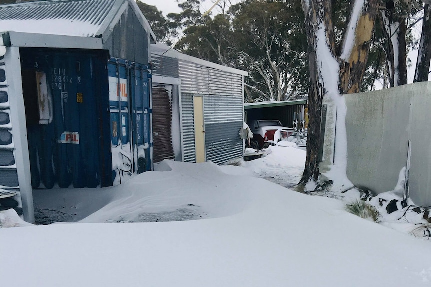 Snow on the ground and covering a house at Miena.