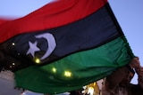 Escalating: a Libyan protester waves his old national flag during a demonstration in the dissident-held city of Tobruk