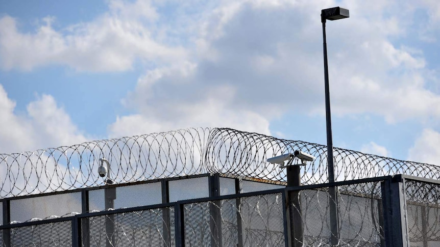 Razor wire on top of a perimeter fence at a prison.