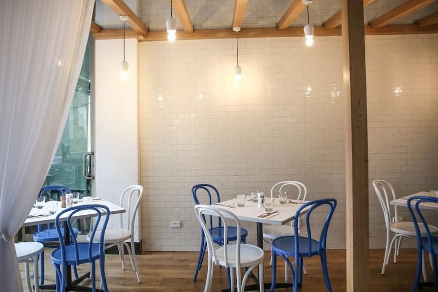 Dining tables and chairs at a ENA Greek Street Food restaurant.