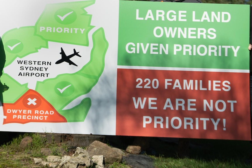 A sign that reads "large land owners given priority 220 familes we are not priority"