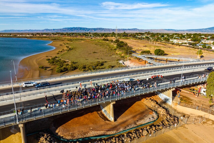 A drone shot of people congregated on the bridge. 