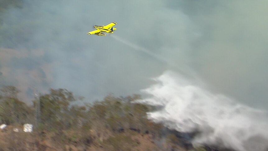 plane waterbombing over a bushfire