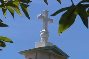 A crucifix sits atop a Christian school (ABC News: File Photo)