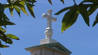 A crucifix sits atop a Christian school (ABC News: File Photo)