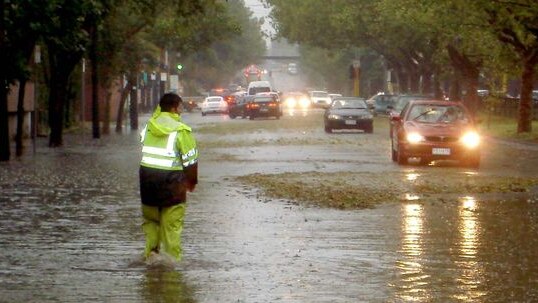 An emergency worker wades through floodwaters