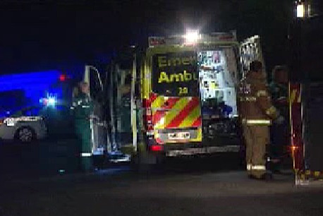Ambulance crews treat a man after a house fire.