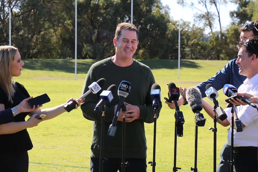 Ross Lyon speaks at a press conference at a park.