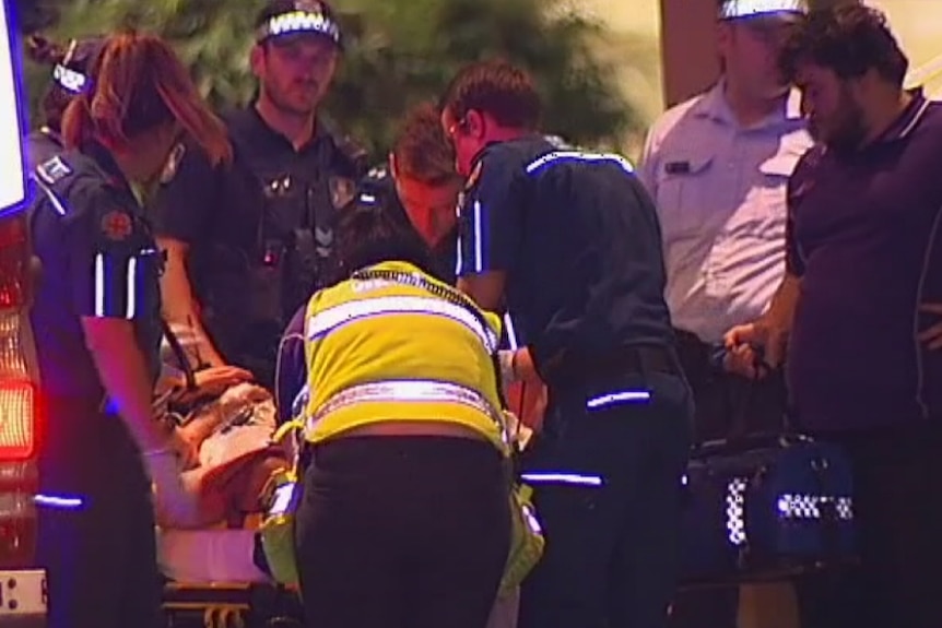 Paramedics attend to an 18-year-old victim of a suspected random one-punch attack