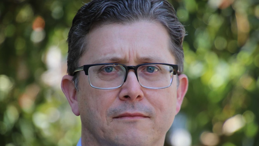 A close up of a man wearing glasses.