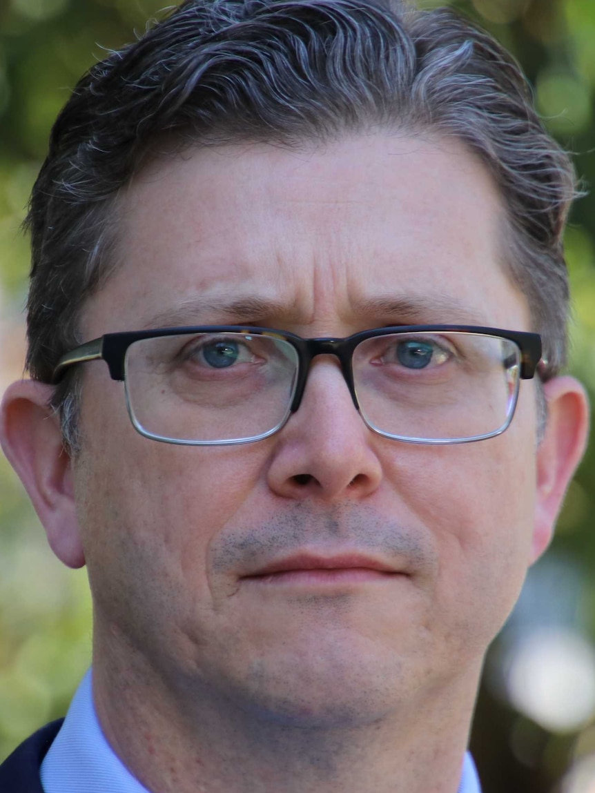 A close up of a man wearing glasses.