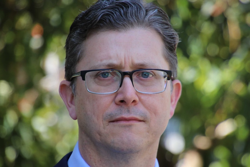 A close up of a man wearing glasses.