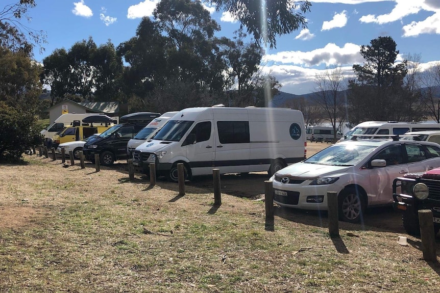 A shot of the carpark filled with cars, vans and camper vans.