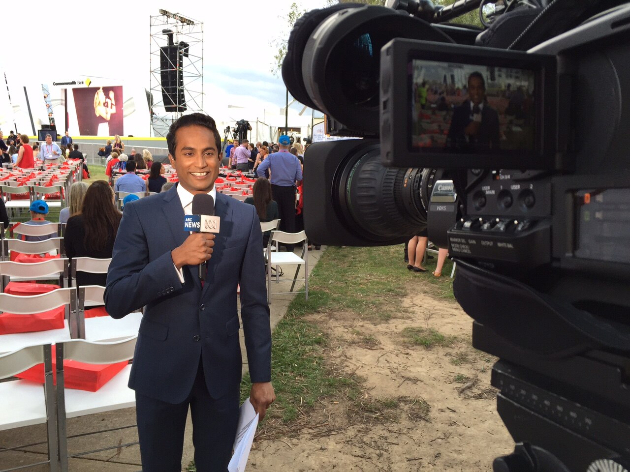  A man holds a microphone while standing in front of a microphone