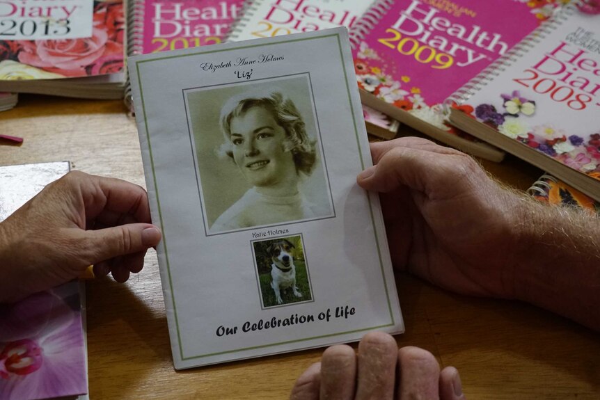 Diaries can be seen spread out. In the foreground is a 'celebration of life' booklet for Liz Holmes and her dog Katie.