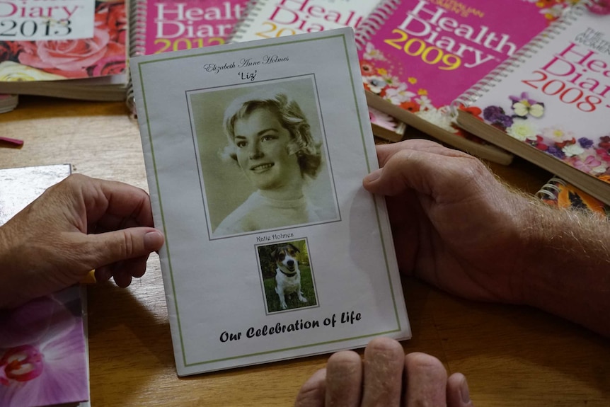 Diaries can be seen spread out. In the foreground is a 'celebration of life' booklet for Liz Holmes and her dog Katie.