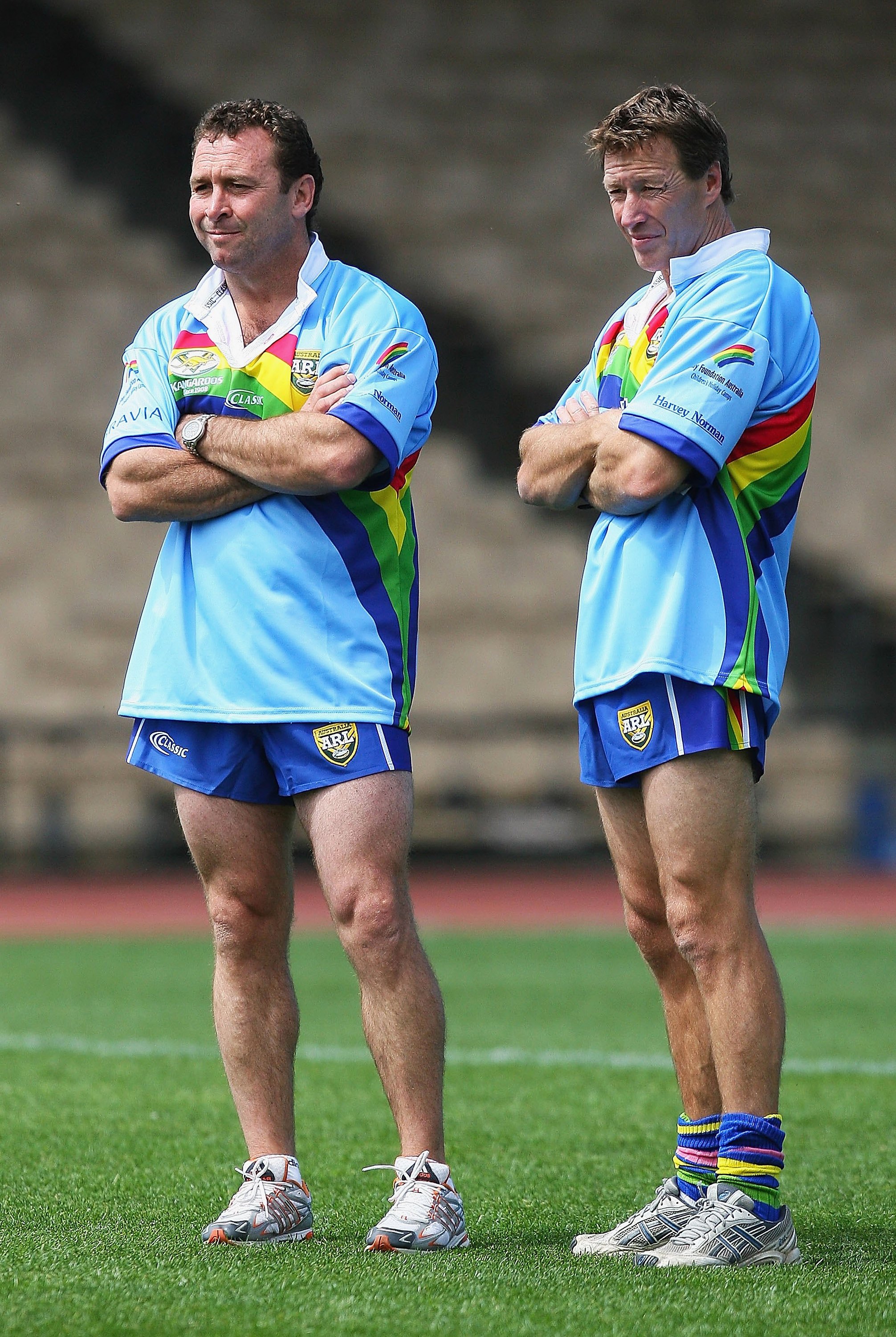 Two coaches watch their players in action at training.
