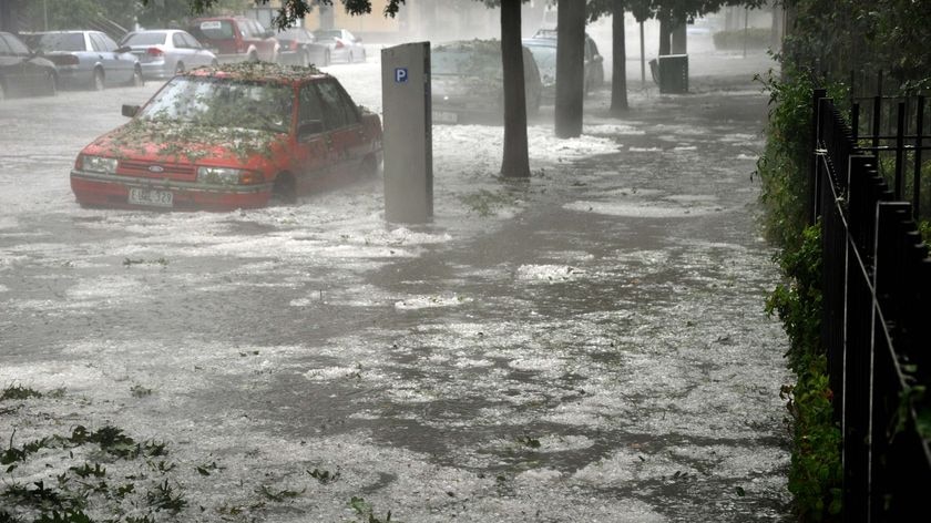 A car sits in a flooded Melbourne street, with hail all around on March 6, 2010.