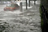 A car sits in a flooded Melbourne street, with hail all around on March 6, 2010.