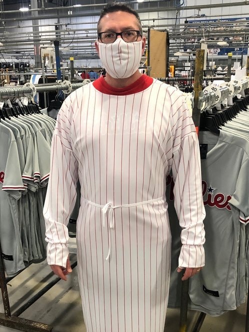 A man wearing a medical gown made from a baseball uniform.
