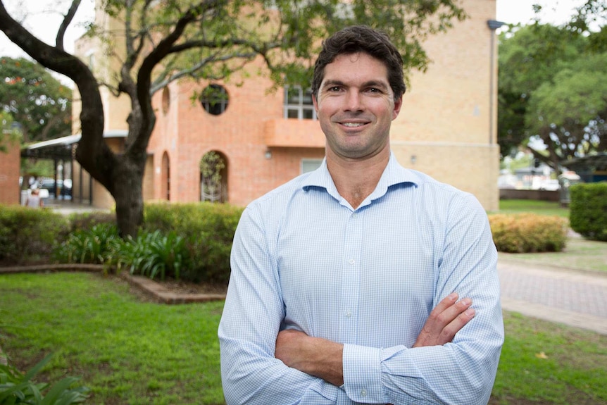 Man in a business shirt standing out doors in front of a building on the TAFE Hunter campus.