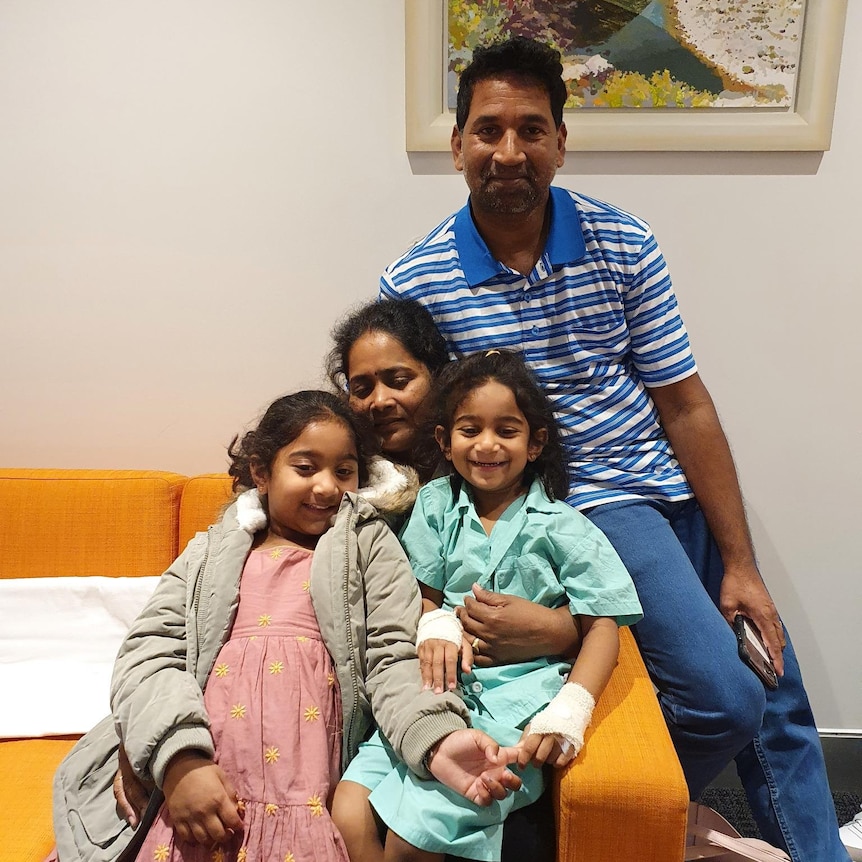 A close-up photo of the Murugappan family with a painting in the background.