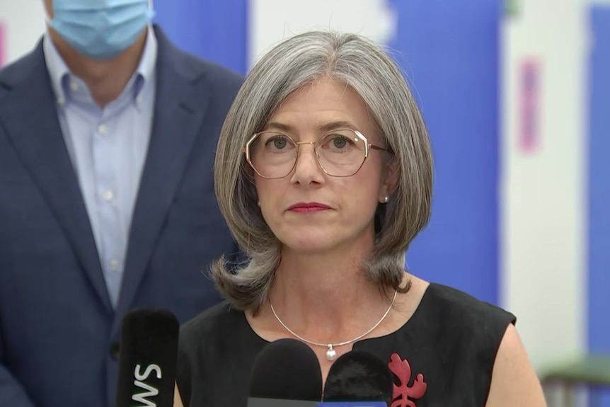 A woman with grey hair and glasses with a slightly concerned expression on her face