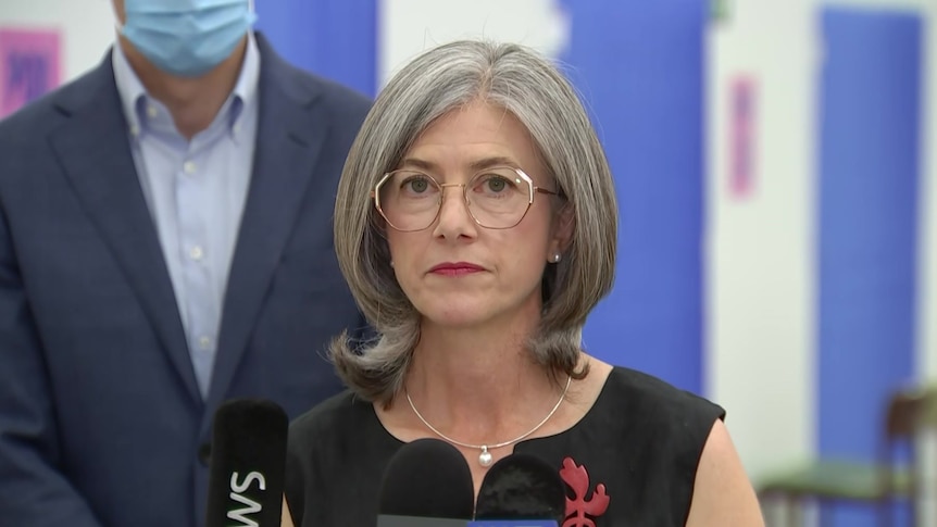 A woman with grey hair and glasses with a slightly concerned expression on her face