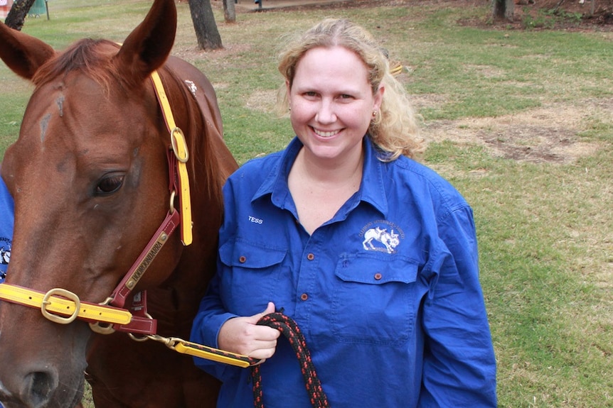 Clermont vet Tess Salmond stands with a horse.