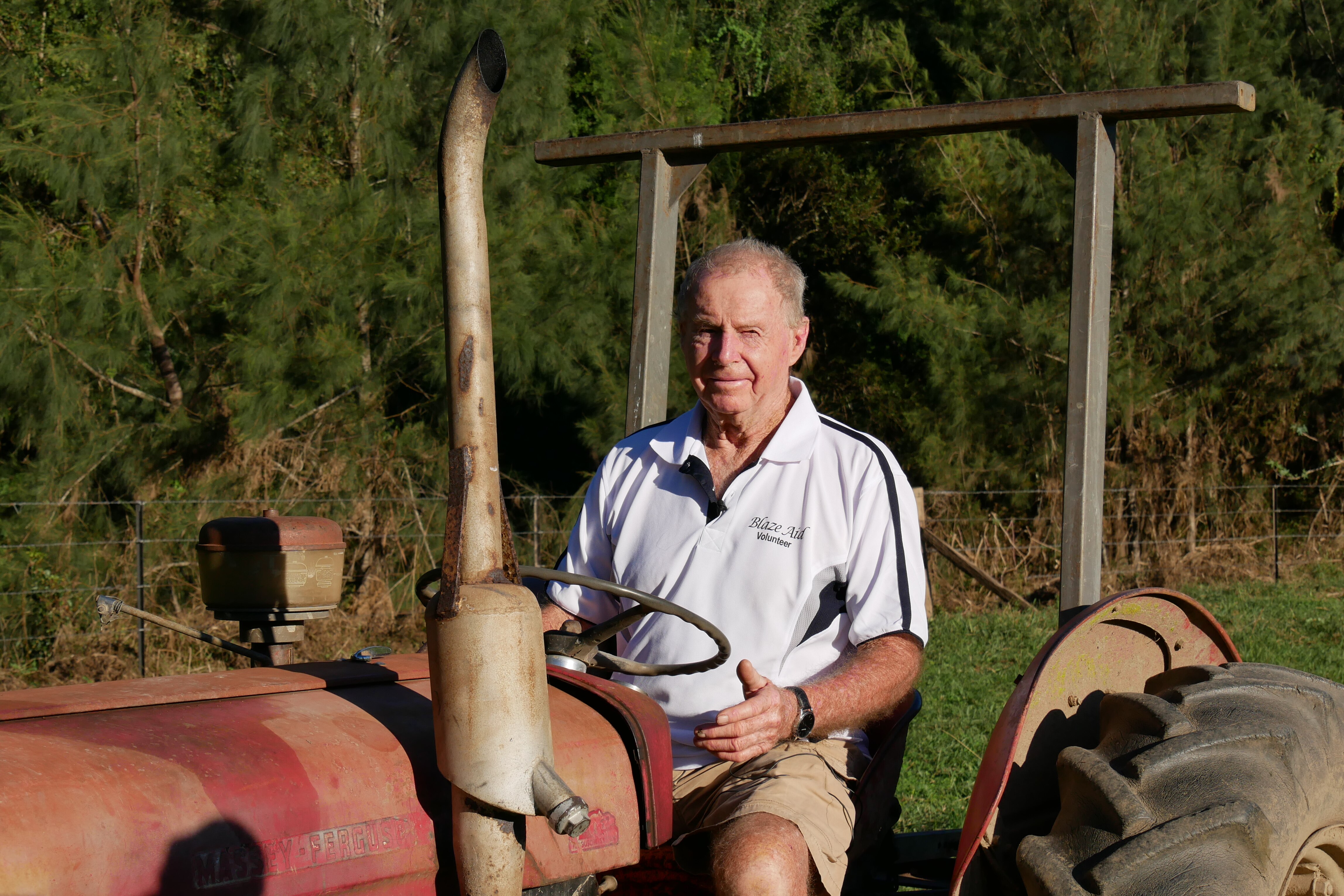 80 year old Bryan Watts sits on his tractor on his farm. 