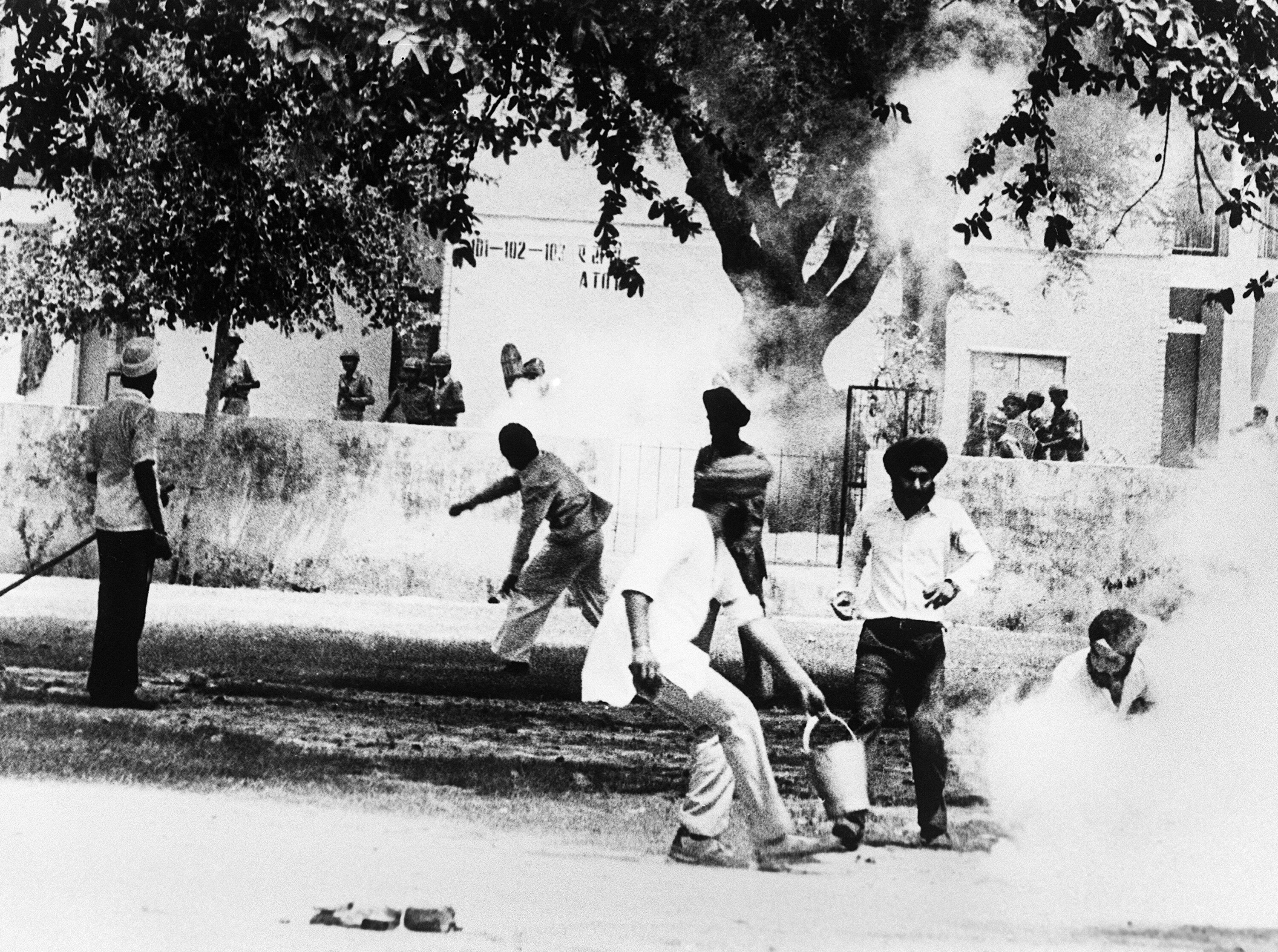 Archival photo of Sikhs militant throw a tear gas canister back at Indian police at the Golden Temple.