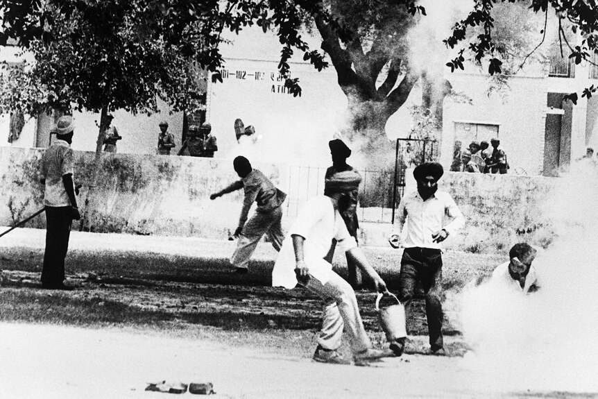 Archival photo of Sikhs militant throw a tear gas canister back at Indian police at the Golden Temple.