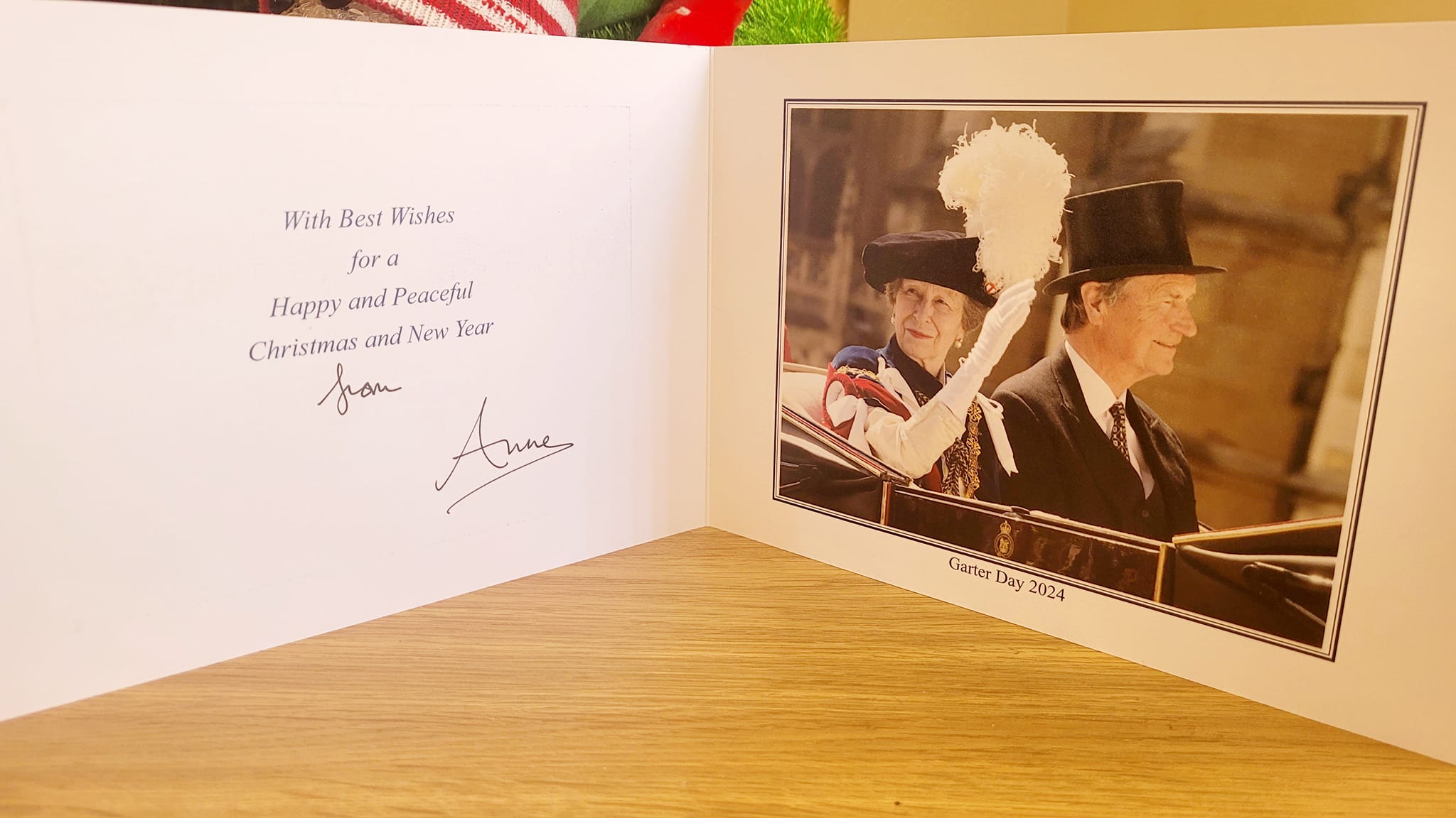 A Christmas card with Princess Anne, her husband and some text on the left hand side