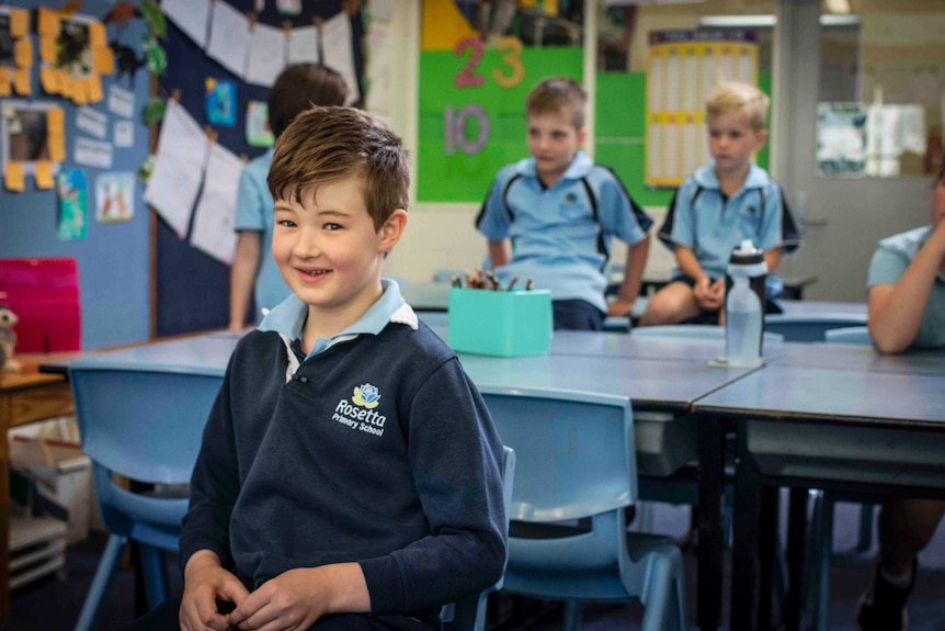 A primary school boy smiles at the camera