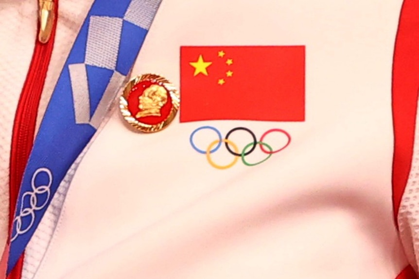 获得金牌的自行车运动员鲍善举和钟天石的运动服上都别着一枚已故中国主席毛泽东的徽章。